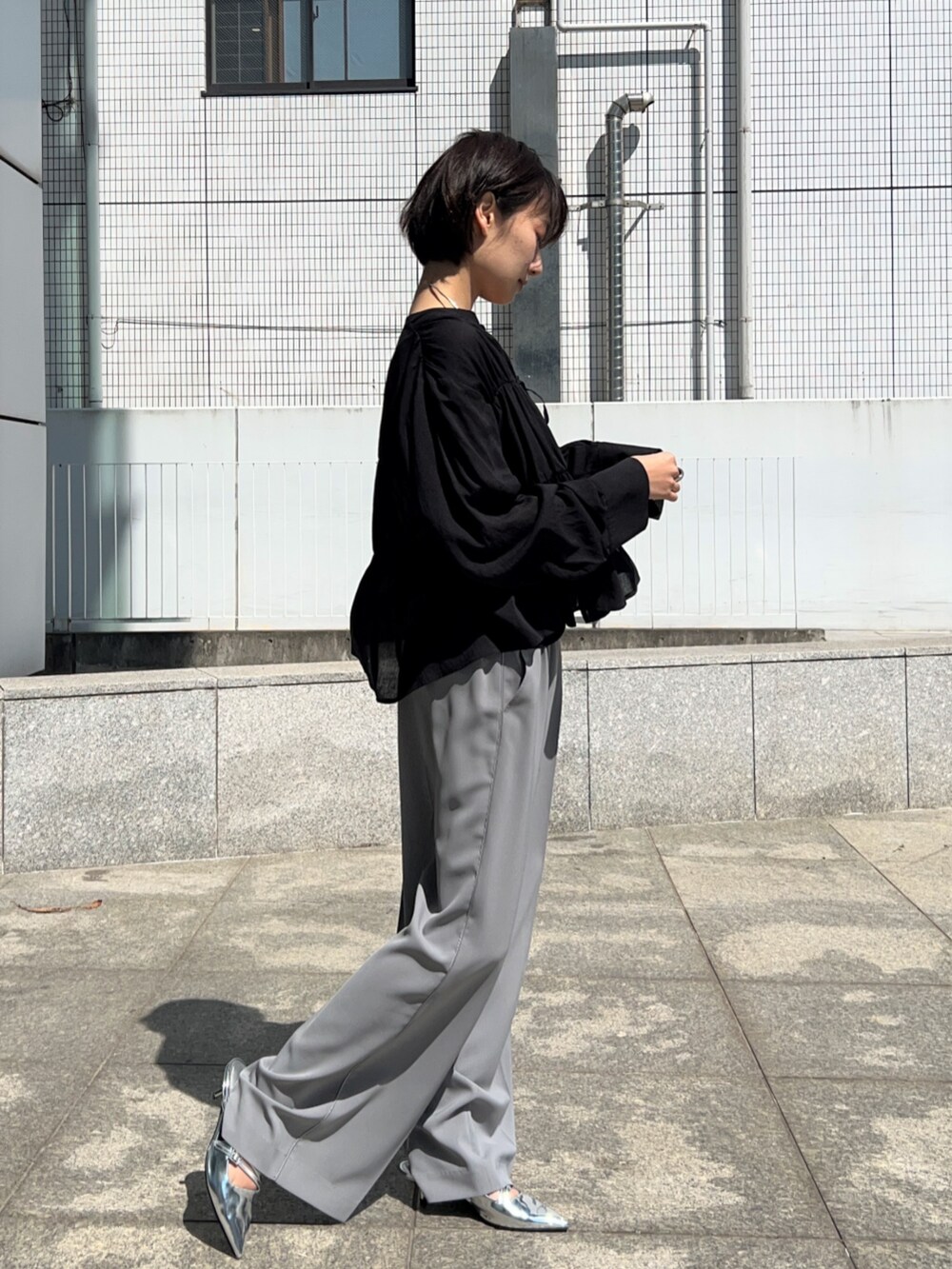 グレー系のその他パンツ、ブラック系のシャツ/ブラウス、ブラック系のタンクトップを着用したレディースの春コーディネートの6枚目の写真