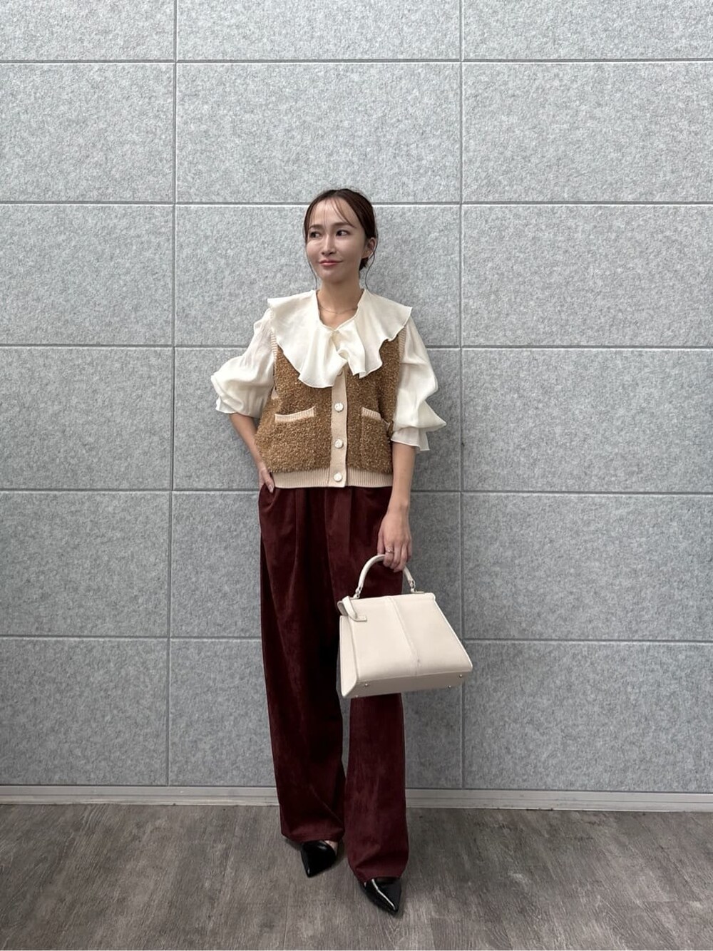 ホワイト系のシャツ/ブラウス、ブラウン系のベスト、レッド系のその他パンツを着用したレディースの秋コーディネートの7枚目の写真