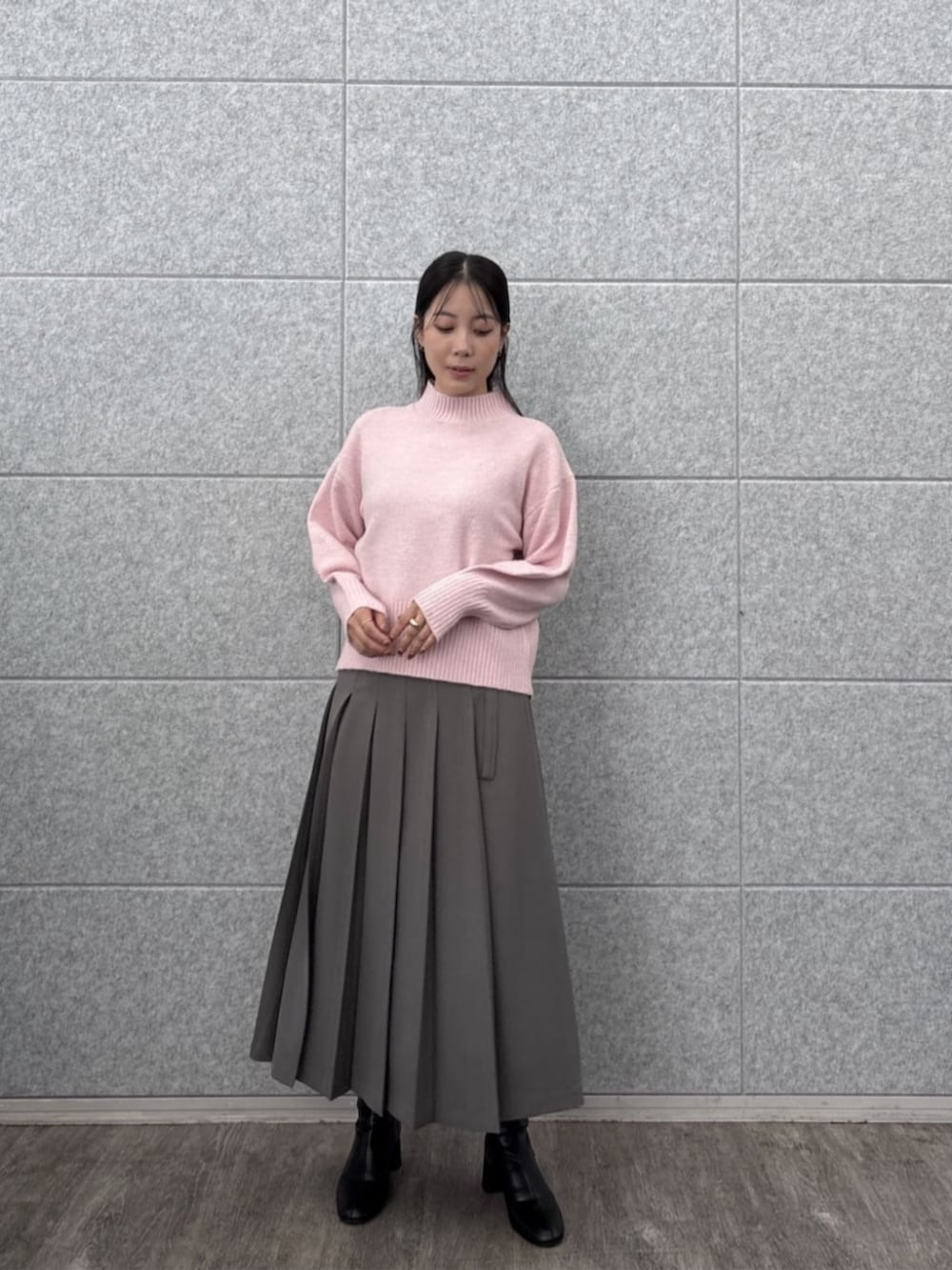 グレー系のスカート、ピンク系のニット/セーターを着用したレディースの秋コーディネートの4枚目の写真