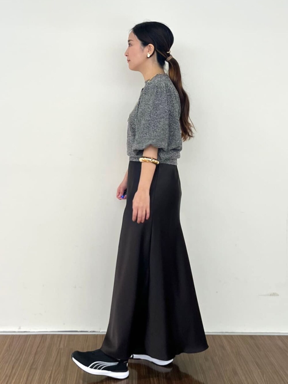 グレー系のスカート、ブラック系のニット/セーターを着用したレディースの秋コーディネートの4枚目の写真