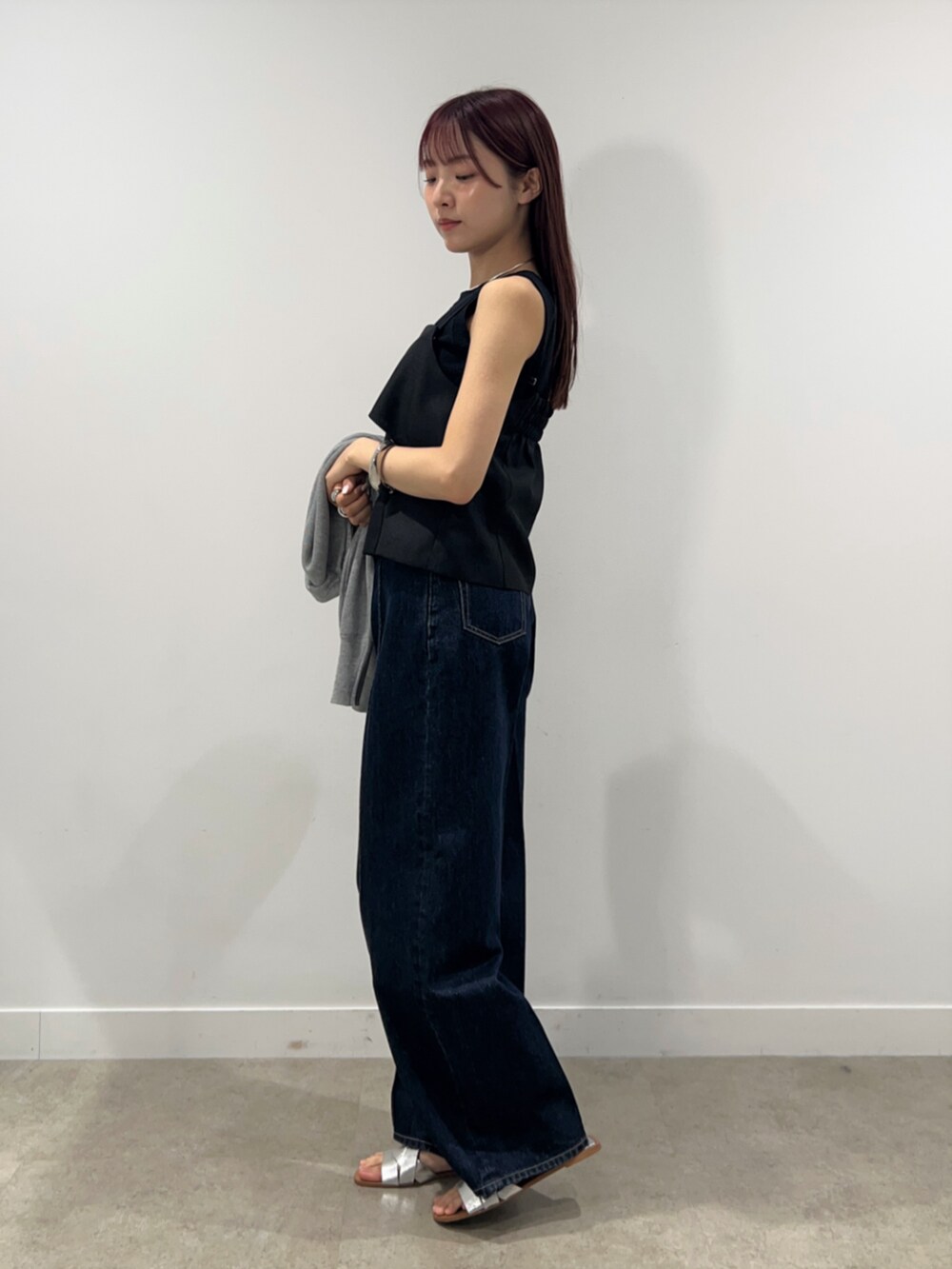 ブルー系のデニムパンツ、グレー系のカーディガン/ボレロ、ブラック系のシャツ/ブラウスを着用したレディースの春コーディネートの8枚目の写真