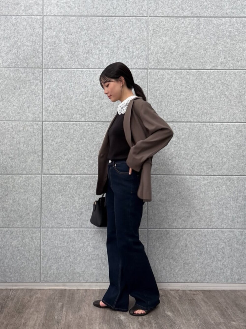 ブラウン系のテーラードジャケット、ブラック系のTシャツ/カットソー、ブルー系のデニムパンツを着用したレディースの秋コーディネートの4枚目の写真