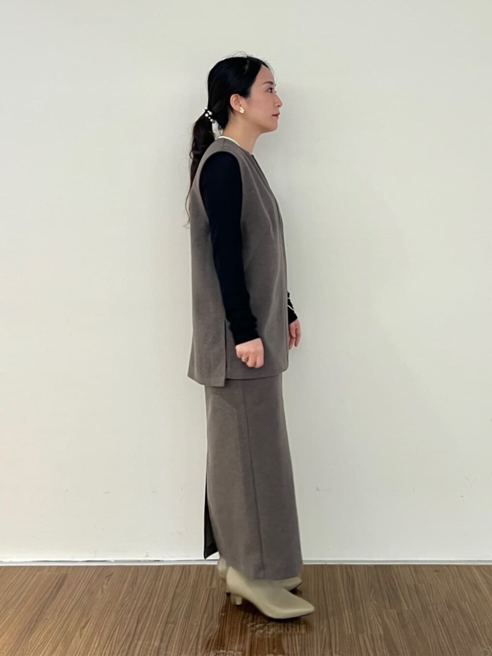 ブラウン系のベスト、ブラウン系のスカート、ブラック系のTシャツ/カットソーを着用したレディースの秋コーディネートの4枚目の写真