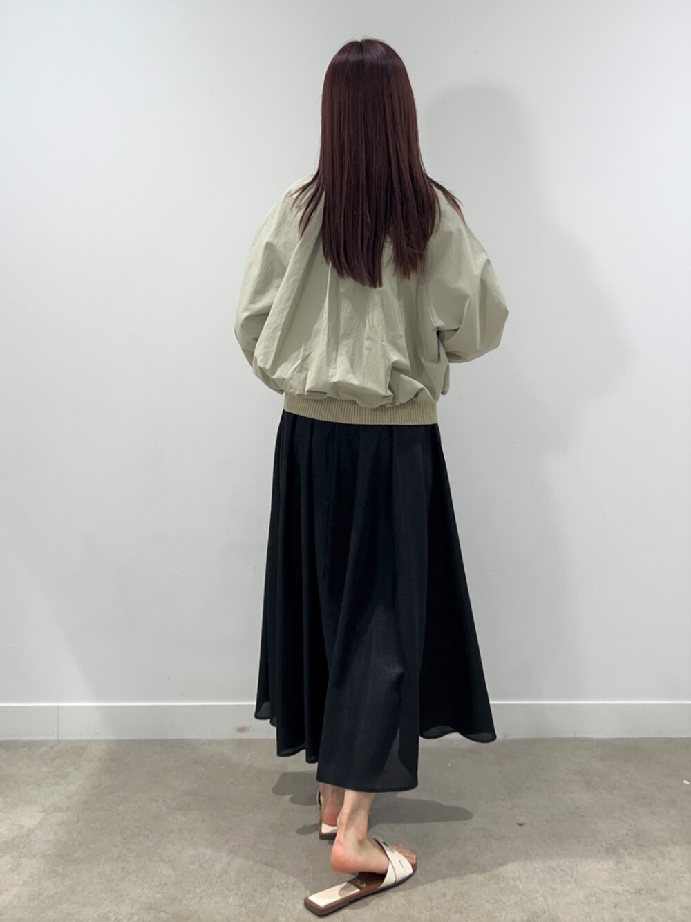 ベージュ系のブルゾン、ベージュ系のニット/セーター、ブラック系のスカートを着用したレディースの春コーディネートの2枚目の写真