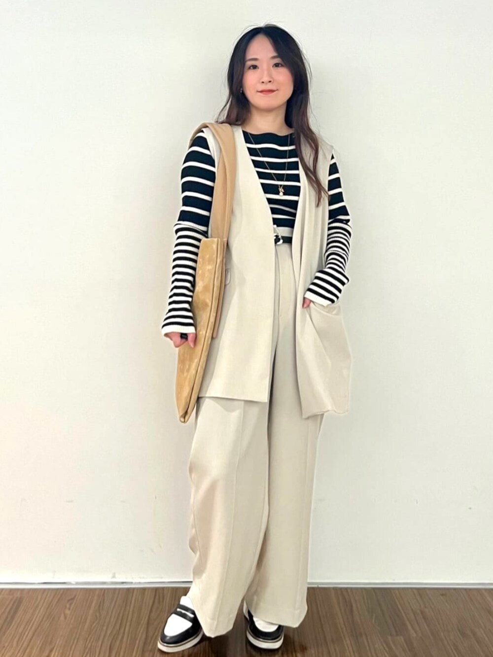 ブラック系のニット/セーター、ベージュ系のその他パンツを着用したレディースの秋コーディネートの3枚目の写真