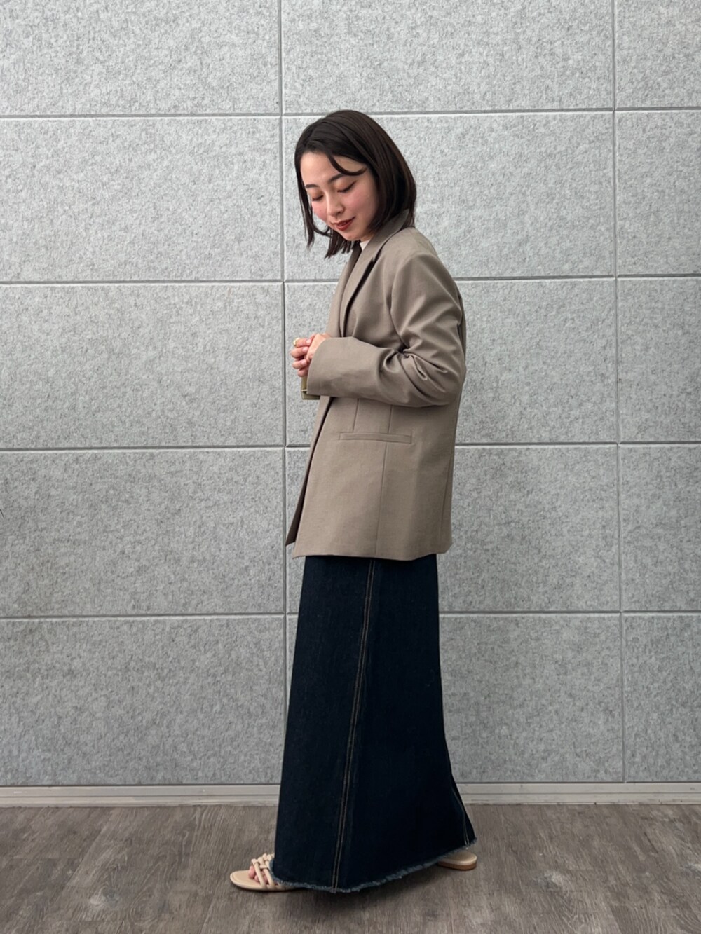 ブラウン系のテーラードジャケット、ブルー系のデニムスカート、ホワイト系のTシャツ/カットソーを着用したレディースの春コーディネートの4枚目の写真