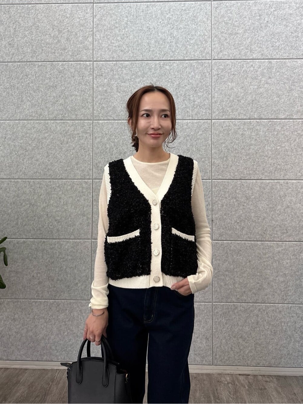 ホワイト系のTシャツ/カットソー、ブラック系のベスト、ブルー系のデニムパンツを着用したレディースの秋コーディネートの6枚目の写真