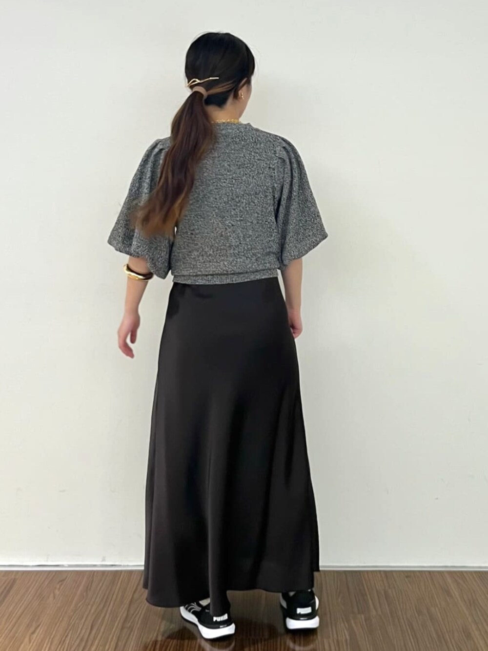 グレー系のスカート、ブラック系のニット/セーターを着用したレディースの秋コーディネートの5枚目の写真