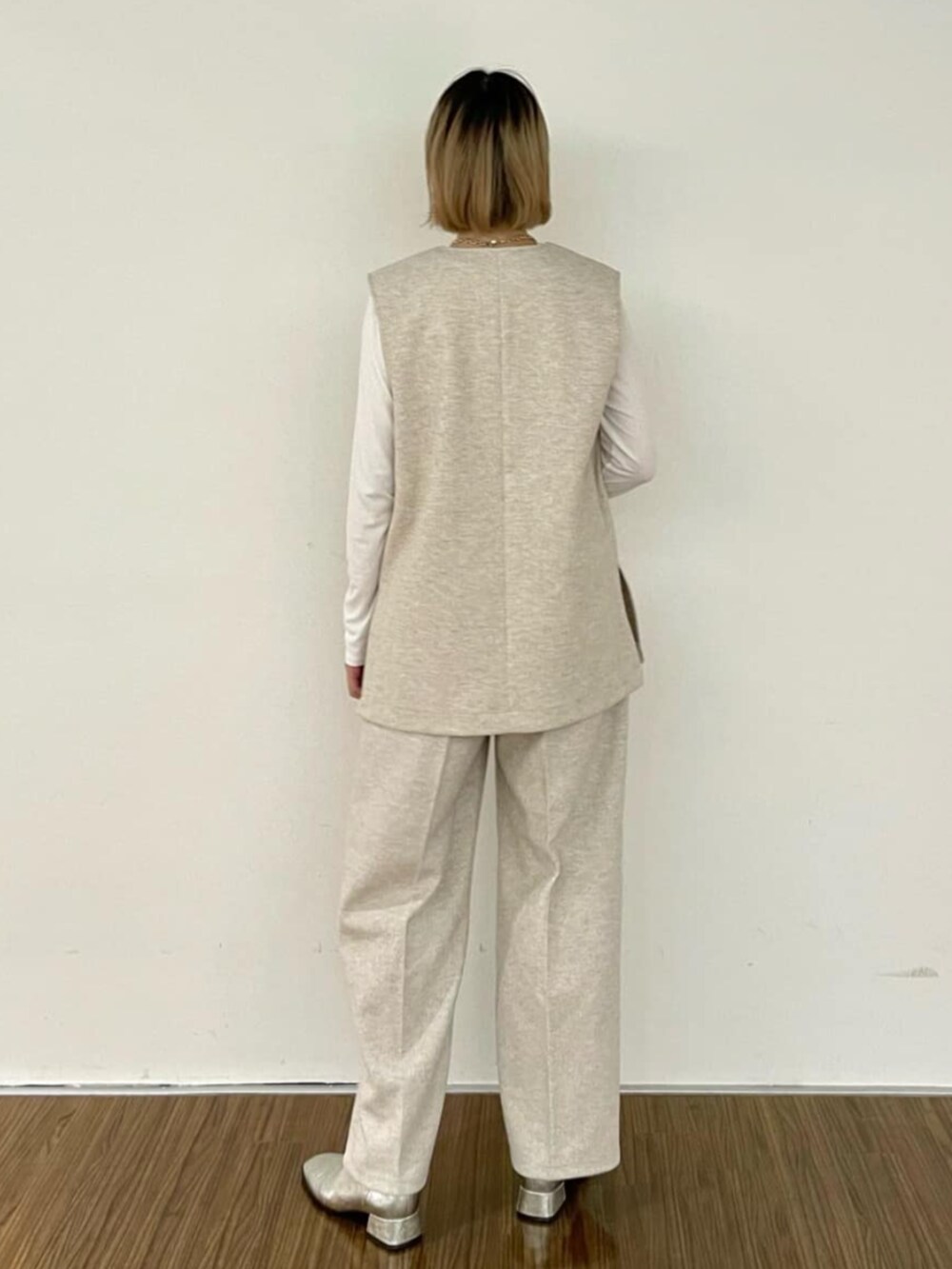 ホワイト系のTシャツ/カットソー、ベージュ系のベスト、ベージュ系のその他パンツを着用したレディースの秋コーディネートの7枚目の写真