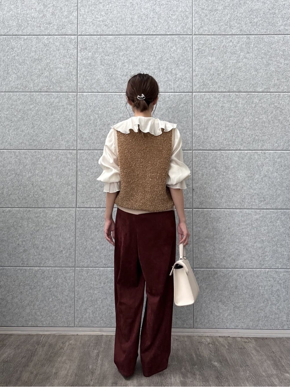ホワイト系のシャツ/ブラウス、ブラウン系のベスト、レッド系のその他パンツを着用したレディースの秋コーディネートの4枚目の写真