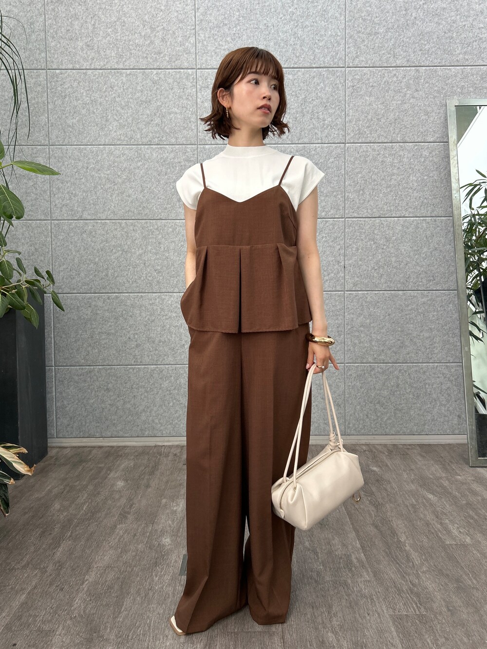 ホワイト系のニット/セーター、ブラウン系のサロペット/オーバーオールを着用したレディースの夏コーディネートの6枚目の写真