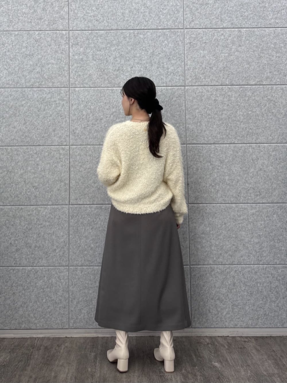 ホワイト系のニット/セーター、グレー系のスカートを着用したレディースの秋コーディネートの2枚目の写真