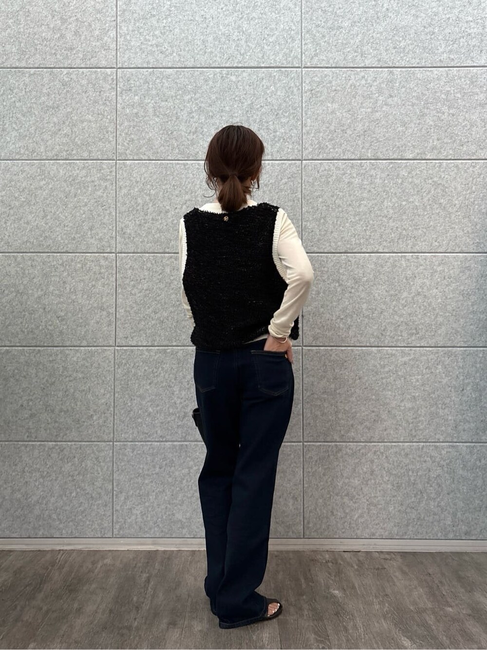 ホワイト系のTシャツ/カットソー、ブラック系のベスト、ブルー系のデニムパンツを着用したレディースの秋コーディネートの3枚目の写真