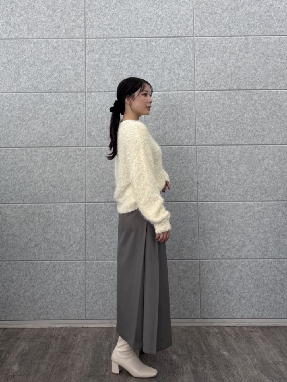 ホワイト系のニット/セーター、グレー系のスカートを着用したレディースの秋コーディネートの6枚目の写真