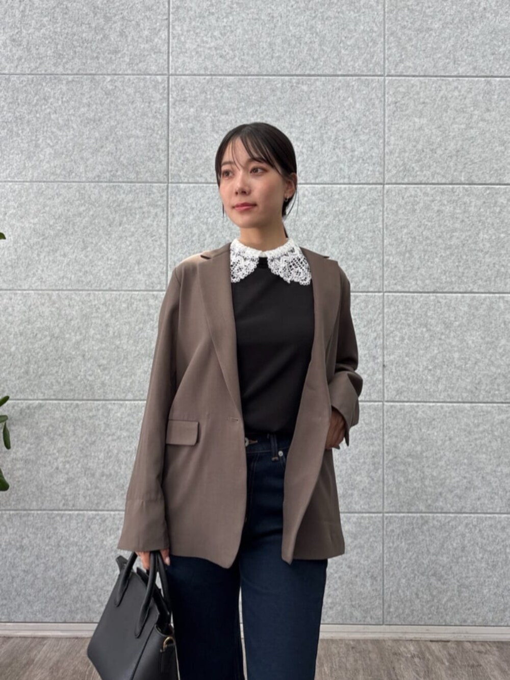 ブラウン系のテーラードジャケット、ブラック系のTシャツ/カットソー、ブルー系のデニムパンツを着用したレディースの秋コーディネートの7枚目の写真