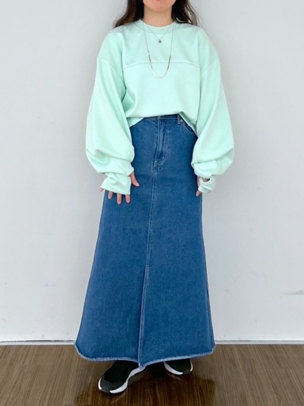 ブルー系のデニムスカート、グリーン系のスウェットを着用したレディースの春コーディネートの3枚目の写真