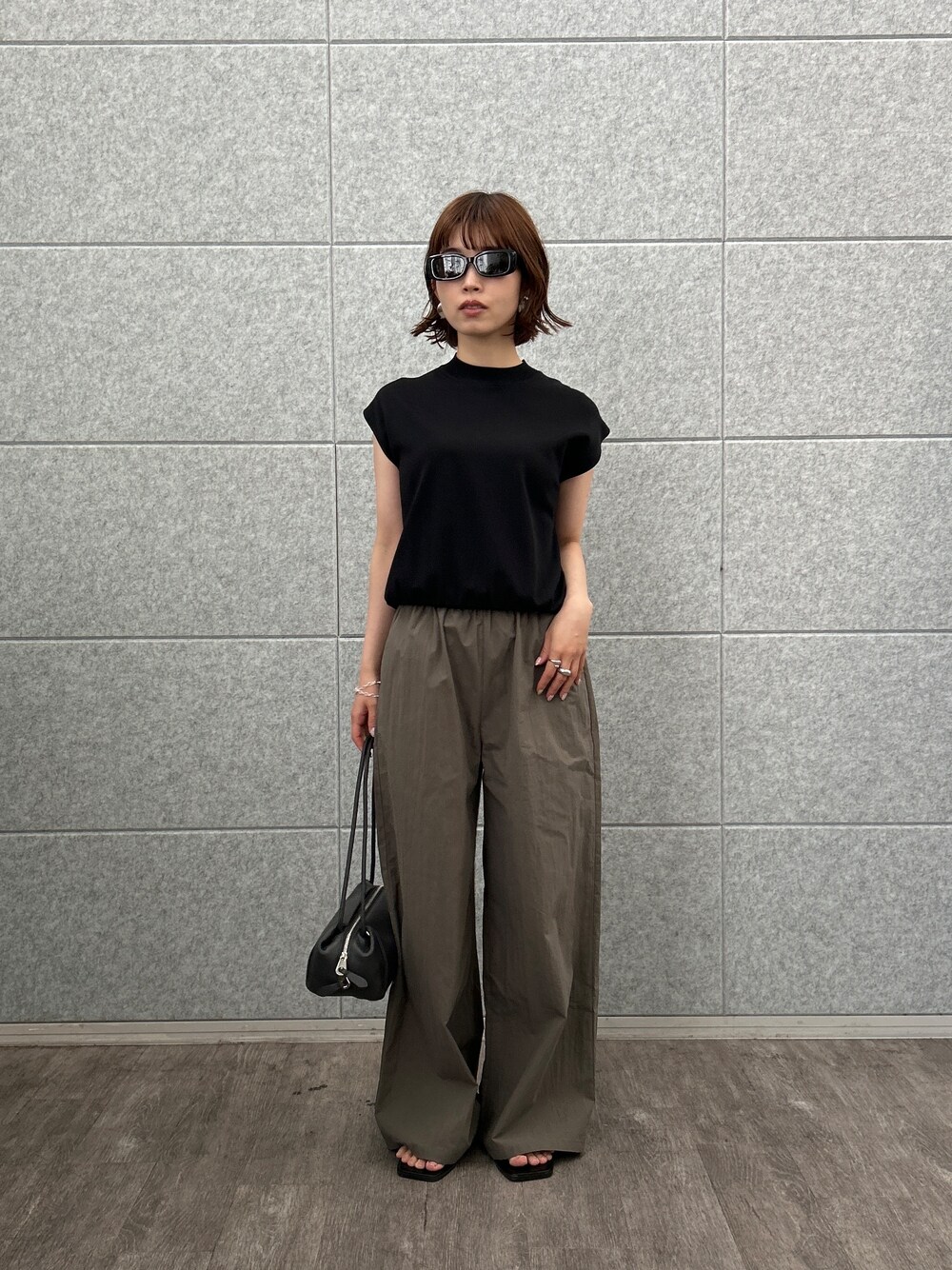 ブラック系のニット/セーター、グリーン系のその他パンツを着用したレディースの夏コーディネートの2枚目の写真