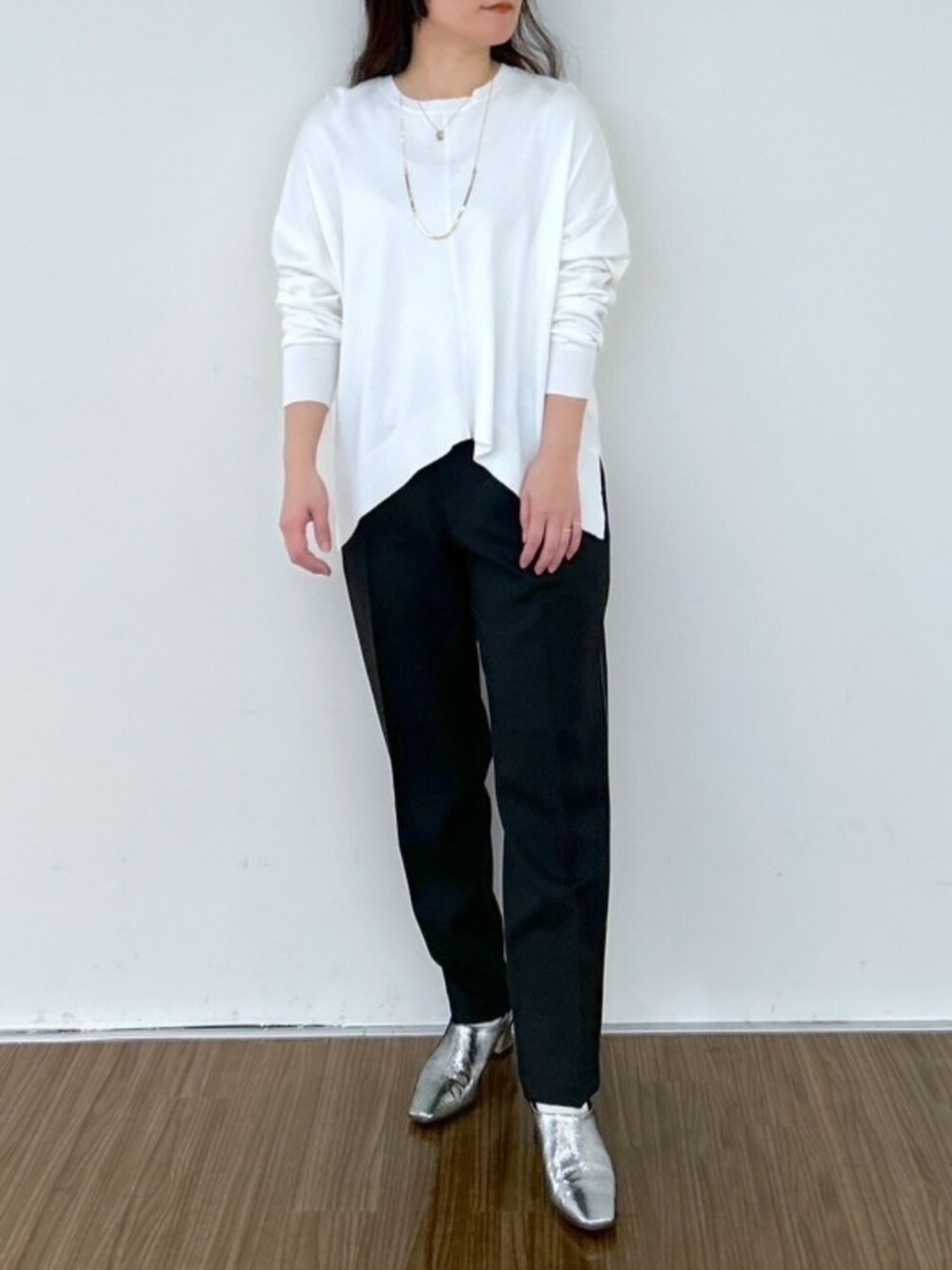 ホワイト系のニット/セーター、ブラック系のその他パンツを着用したレディースの春コーディネートの2枚目の写真