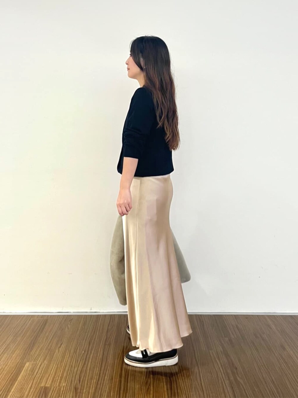 ベージュ系のスカート、ブラック系のカーディガン/ボレロを着用したレディースの秋コーディネートの2枚目の写真