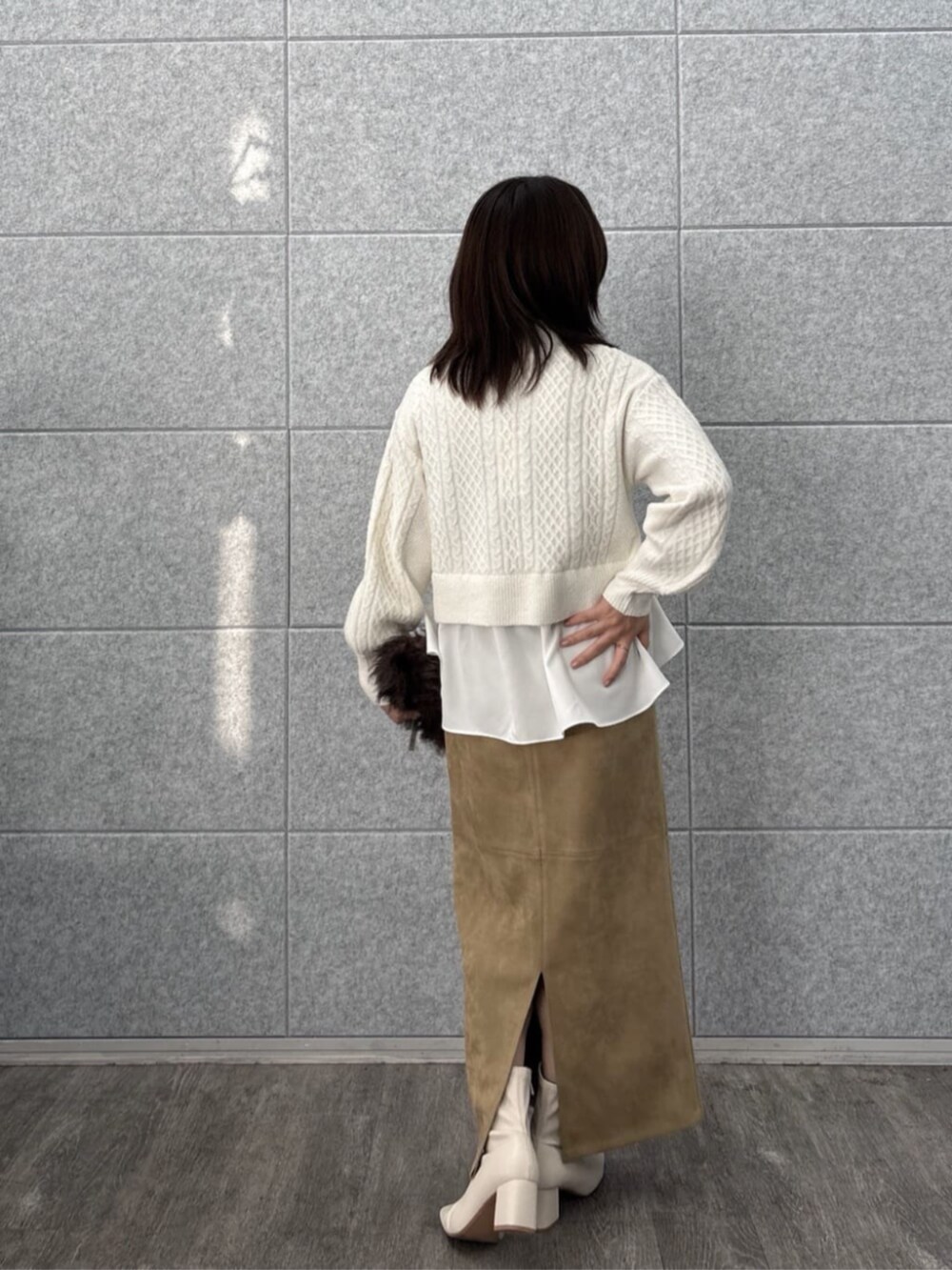 ホワイト系のニット/セーター、ブラウン系のスカートを着用したレディースの冬コーディネートの2枚目の写真