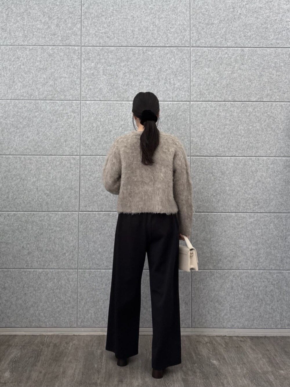 ブラック系のその他パンツ、ホワイト系のニット/セーター、ベージュ系のカーディガン/ボレロを着用したレディースの秋コーディネートの3枚目の写真