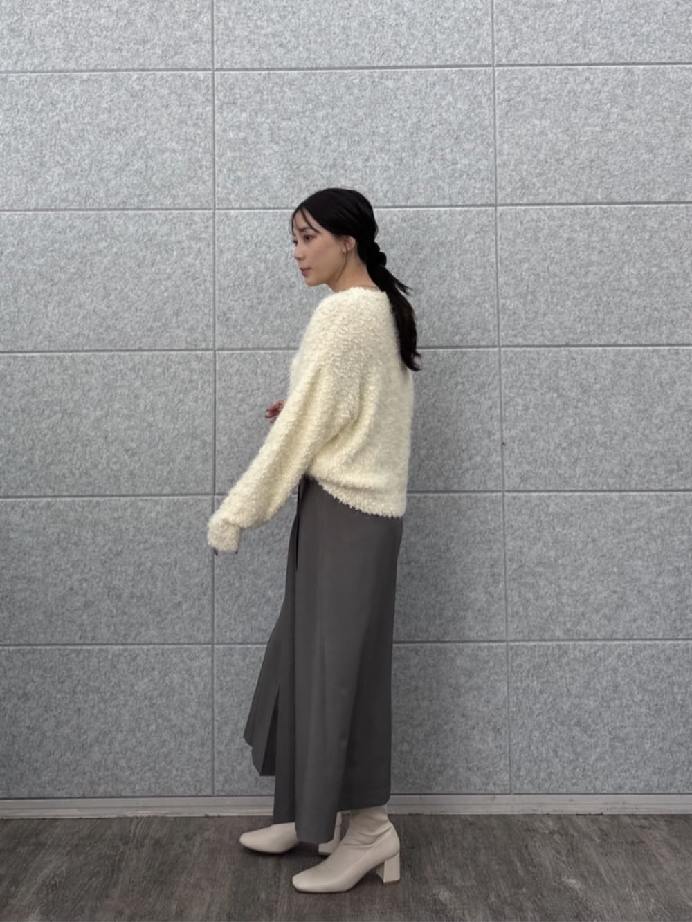 ホワイト系のニット/セーター、グレー系のスカートを着用したレディースの秋コーディネートの4枚目の写真