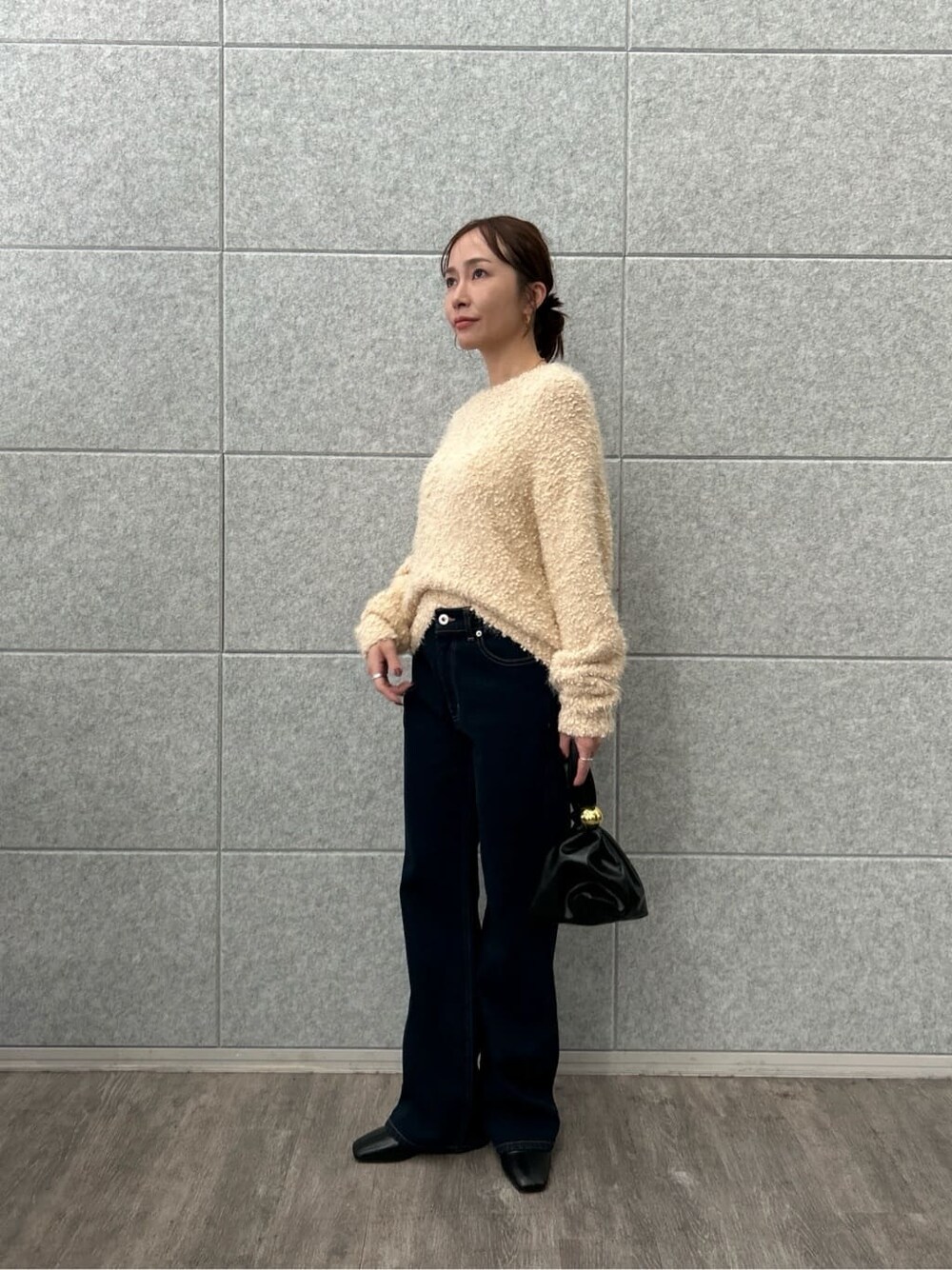 ピンク系のニット/セーター、ブルー系のデニムパンツを着用したレディースの冬コーディネートの4枚目の写真
