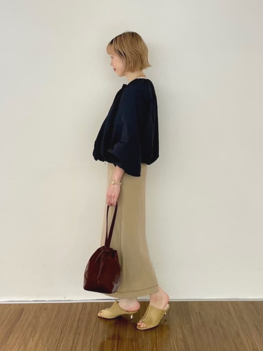 ブラック系のブルゾン、ブラウン系のスカート、ホワイト系のTシャツ/カットソーを着用したレディースの秋コーディネートの5枚目の写真