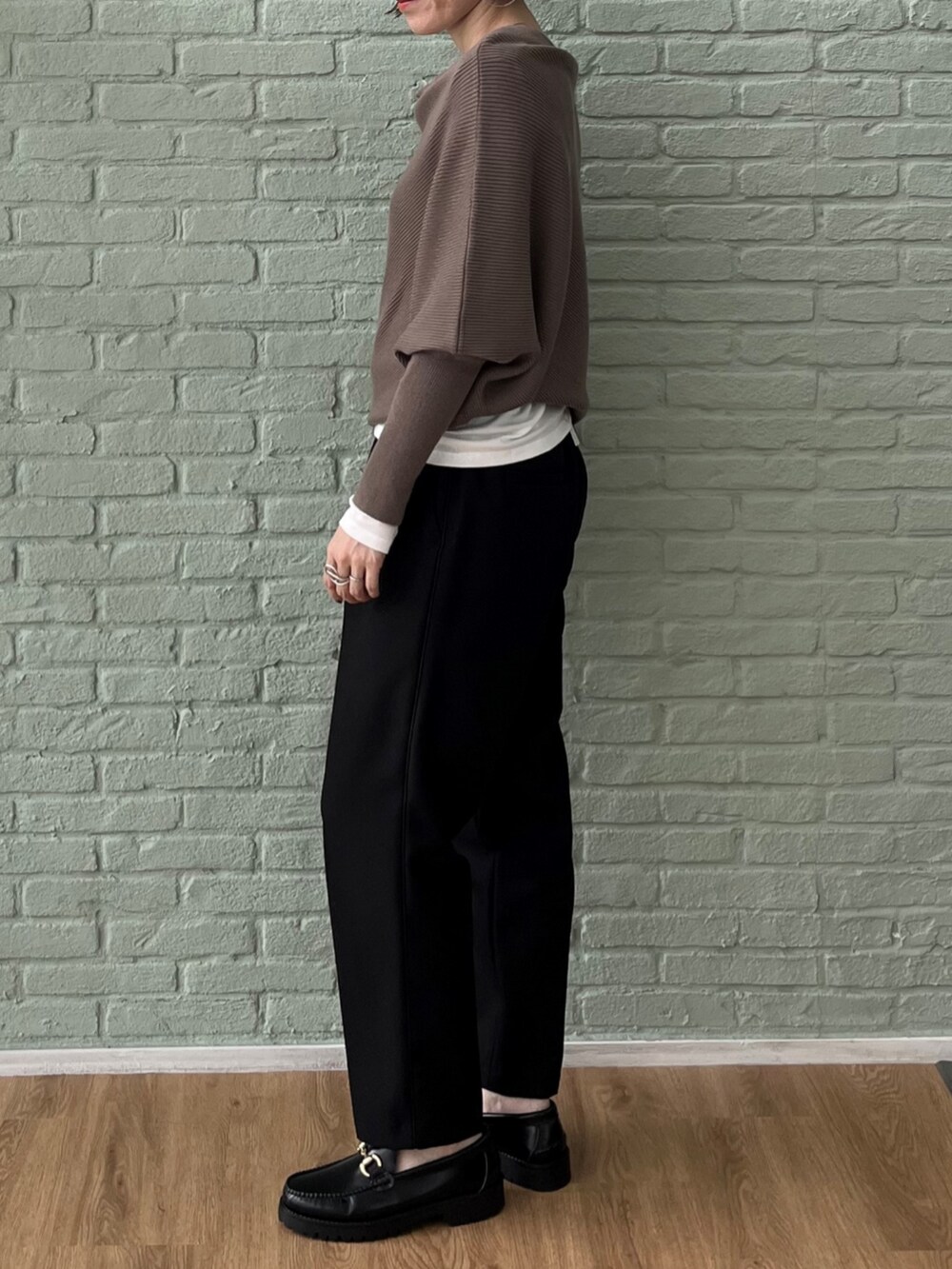 ホワイト系のTシャツ/カットソー、ブラウン系のニット/セーター、ブラック系のその他パンツを着用したレディースの秋コーディネートの3枚目の写真