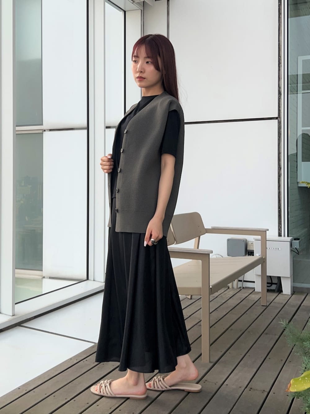 グレー系のベスト、ブラック系のスカート、ブラック系のTシャツ/カットソーを着用したレディースの春コーディネートの4枚目の写真