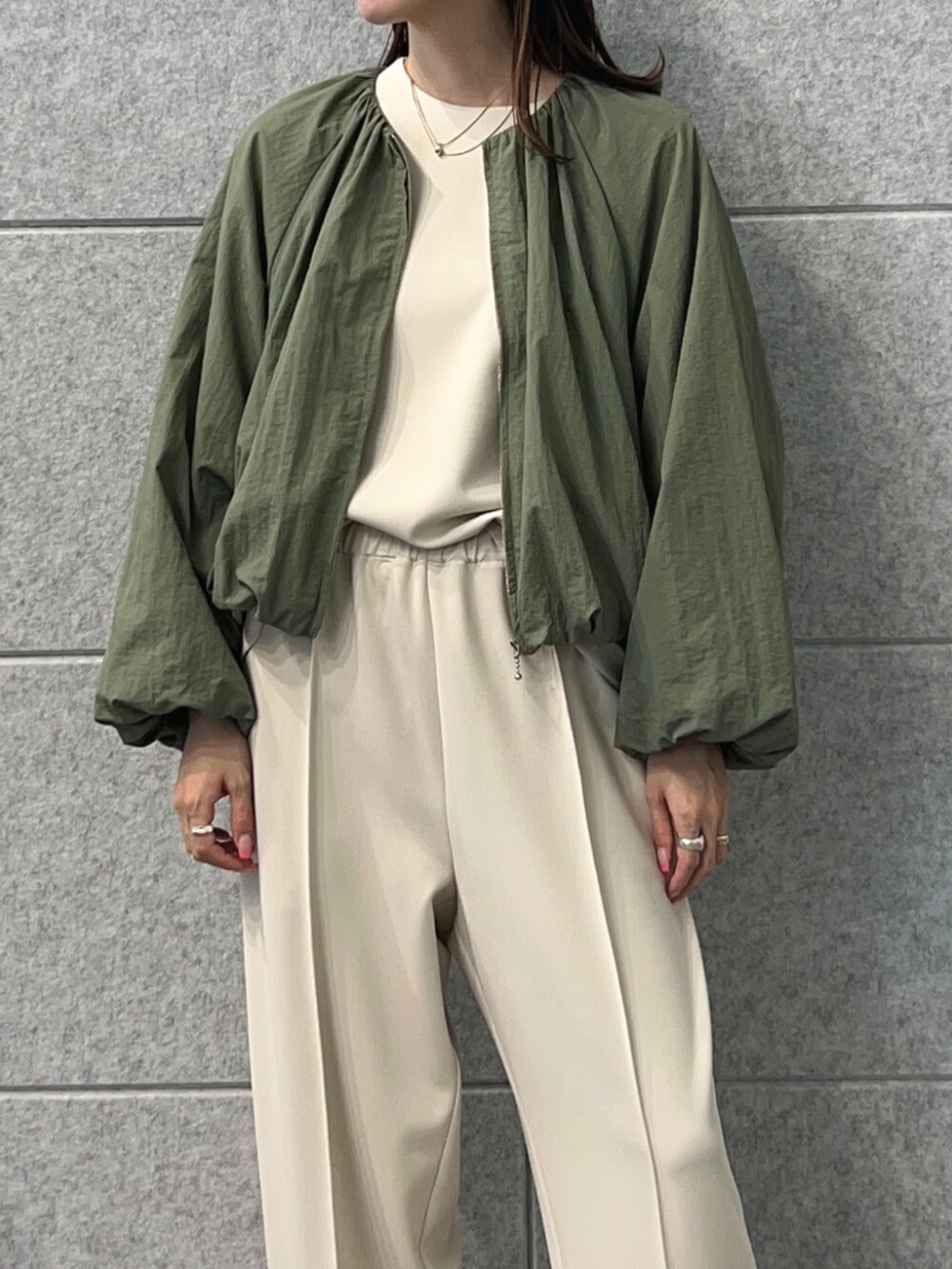 グリーン系のブルゾン、ベージュ系のその他パンツ、ベージュ系のTシャツ/カットソーを着用したレディースの秋コーディネートの6枚目の写真
