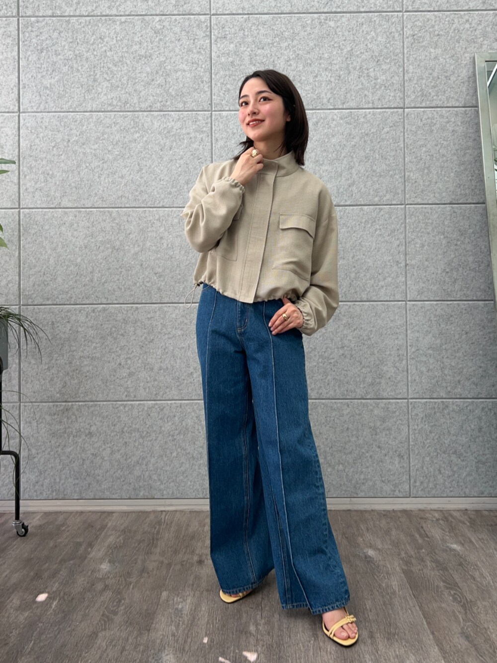 ブルー系のデニムパンツ、グリーン系のブルゾンを着用したレディースの春コーディネートの3枚目の写真