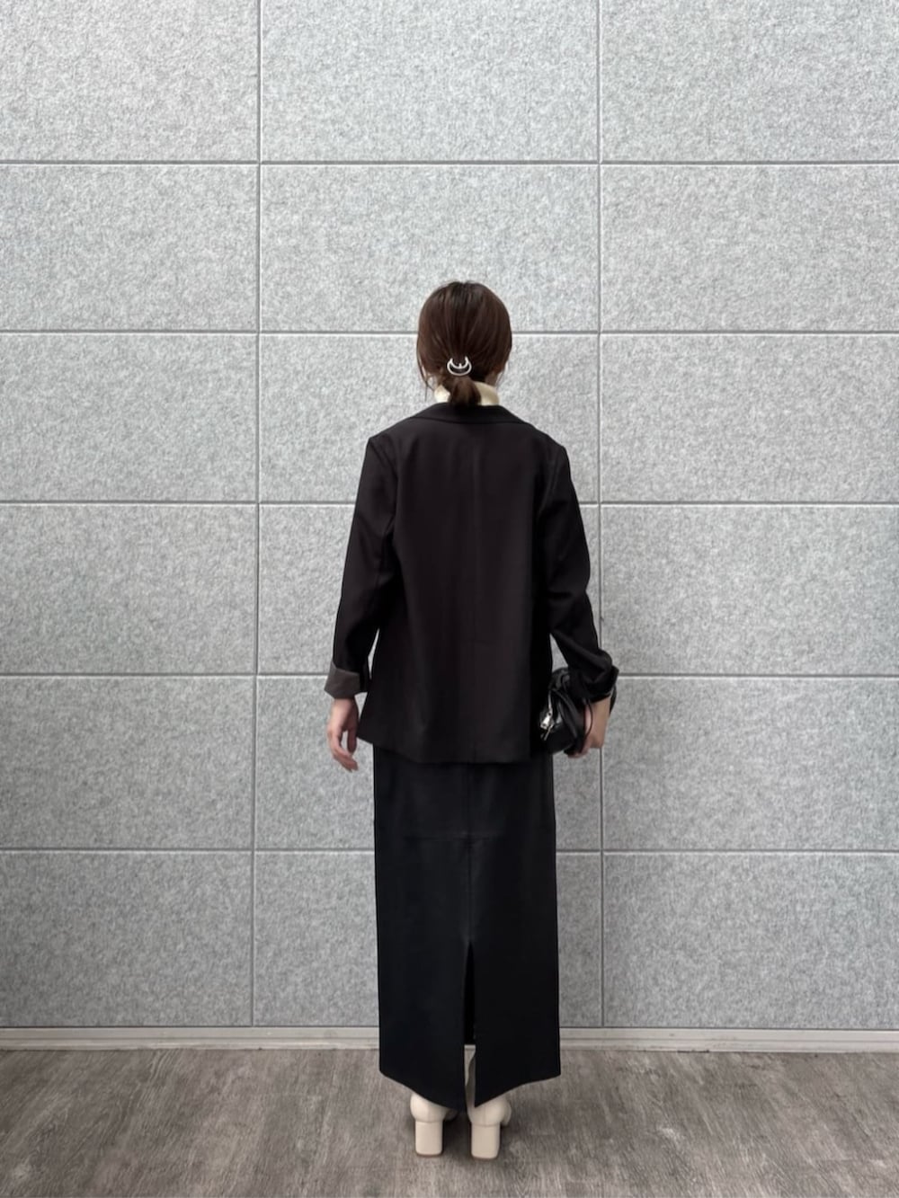 ブラック系のテーラードジャケット、ホワイト系のニット/セーターを着用したレディースの秋コーディネートの4枚目の写真