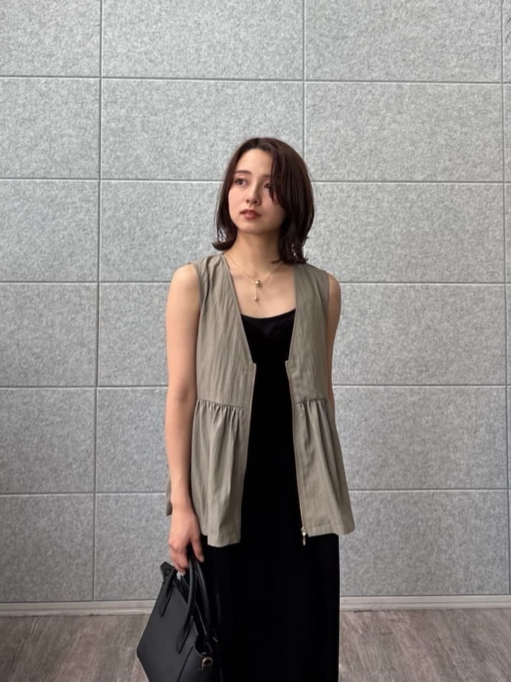 グリーン系のベストを着用したレディースの秋コーディネートの7枚目の写真