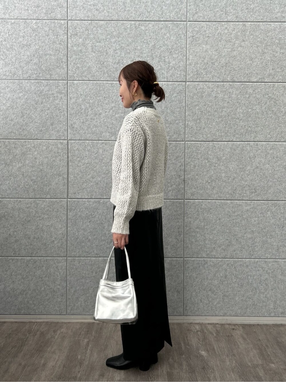 グレー系のニット/セーター、グレー系のTシャツ/カットソー、ブラック系のスカートを着用したレディースの冬コーディネートの6枚目の写真