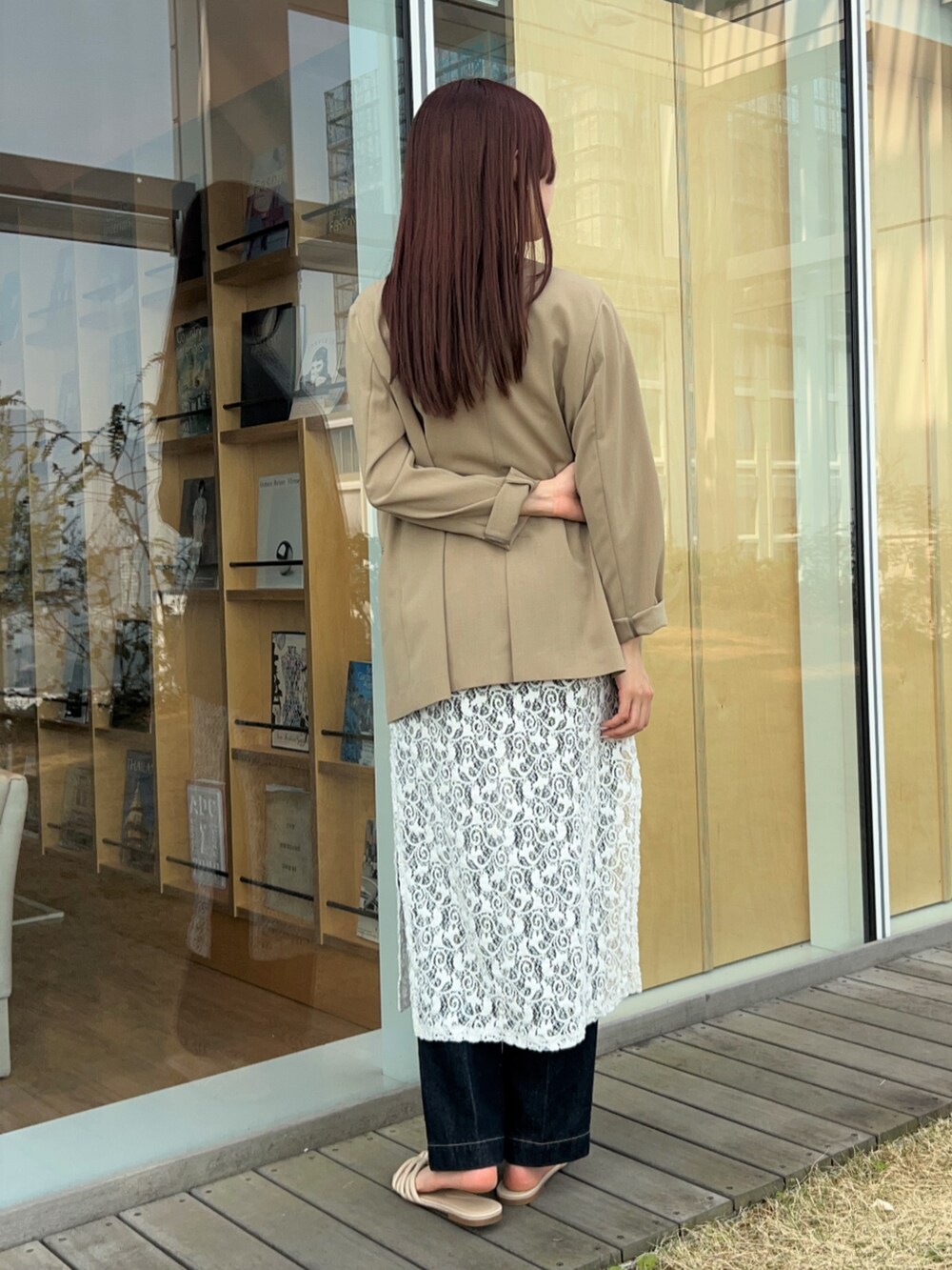 ブルー系のデニムパンツ、ベージュ系のノーカラージャケット、ホワイト系のタンクトップを着用したレディースの春コーディネートの6枚目の写真