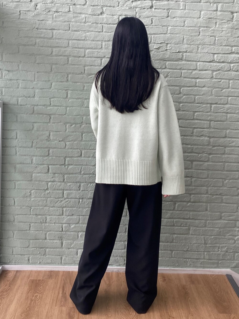 ブラック系のその他パンツ、グリーン系のニット/セーターを着用したレディースの秋コーディネートの4枚目の写真