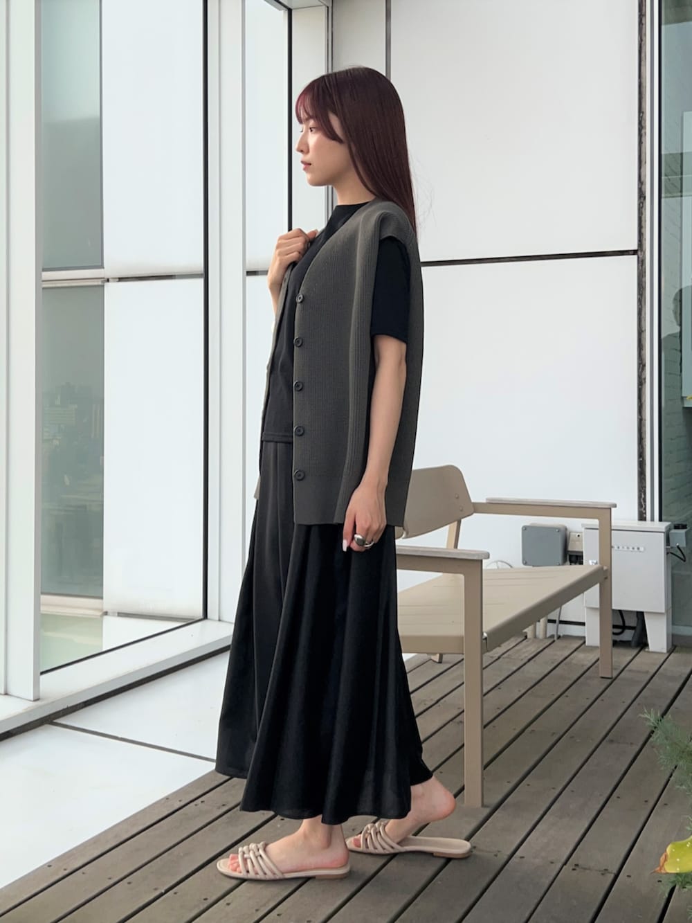 グレー系のベスト、ブラック系のスカート、ブラック系のTシャツ/カットソーを着用したレディースの春コーディネートの5枚目の写真