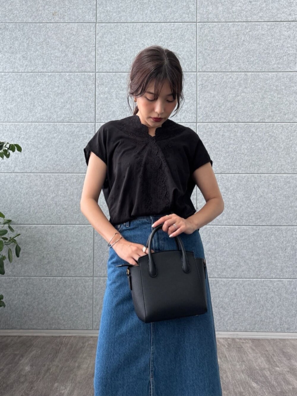 ブルー系のデニムスカート、ブラック系のTシャツ/カットソーを着用したレディースの夏コーディネートの4枚目の写真