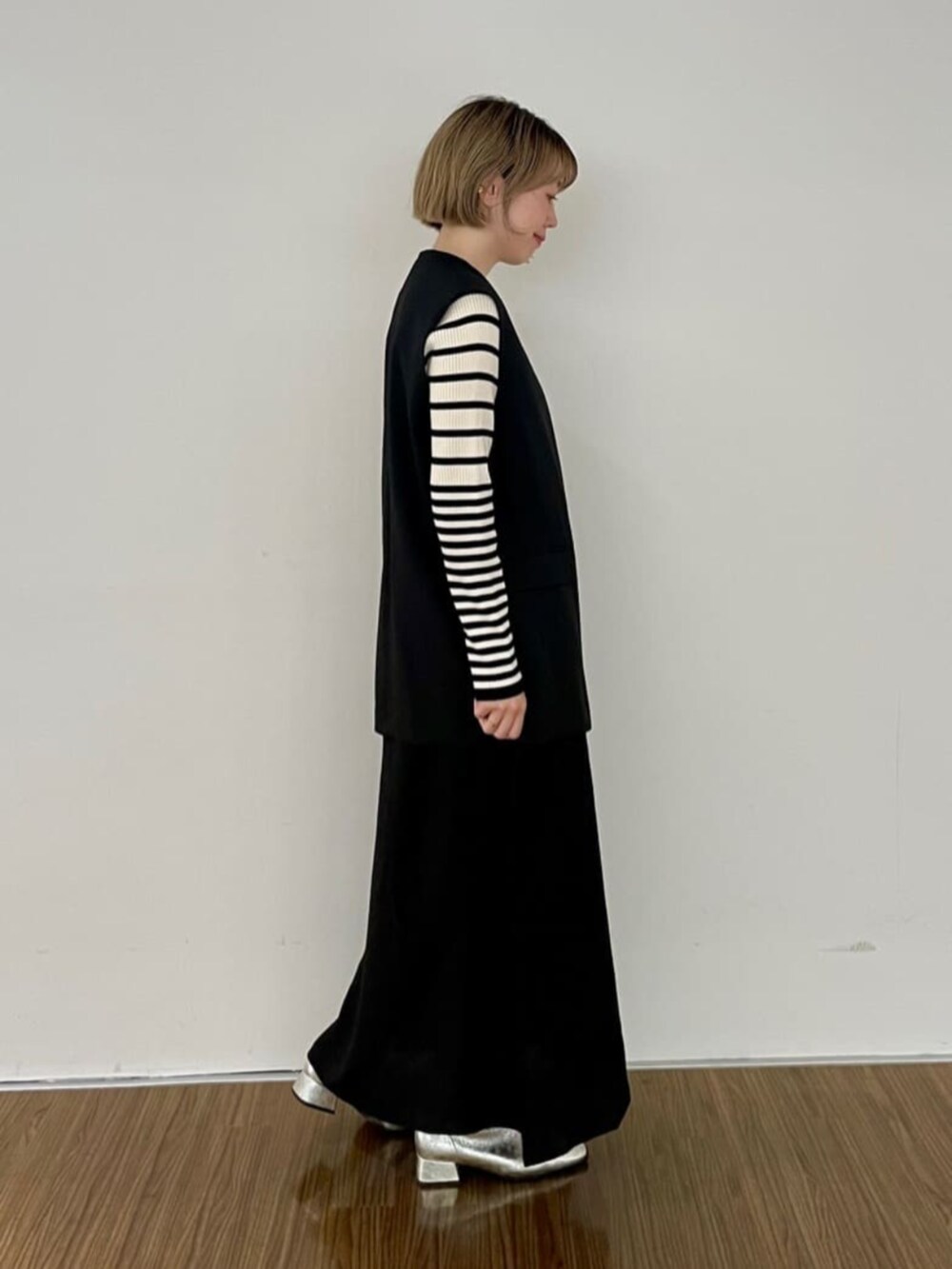 ブラック系のワンピース、ベージュ系のニット/セーター、ブラック系のベストを着用したレディースの秋コーディネートの2枚目の写真