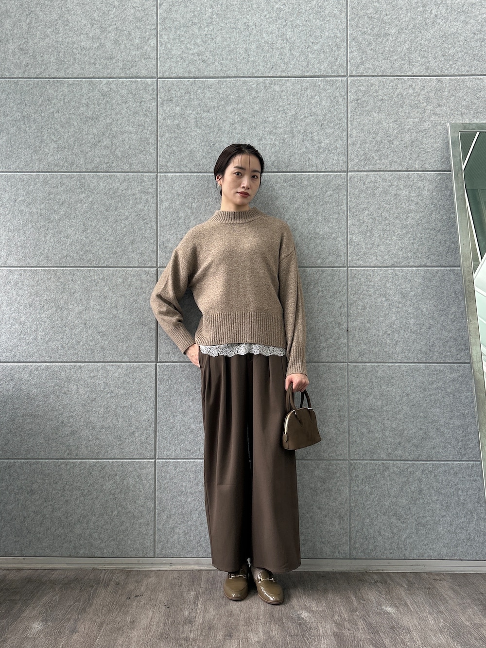 ホワイト系のシャツ/ブラウス、ベージュ系のニット/セーター、ブラウン系のその他パンツを着用したレディースの秋コーディネートの6枚目の写真