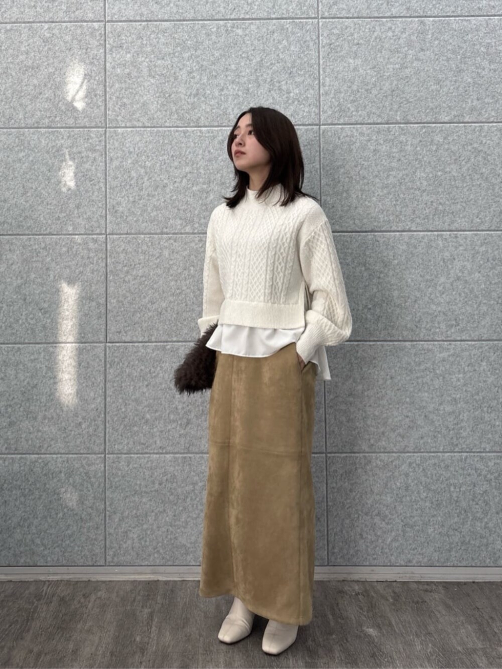 ホワイト系のニット/セーター、ブラウン系のスカートを着用したレディースの冬コーディネートの3枚目の写真
