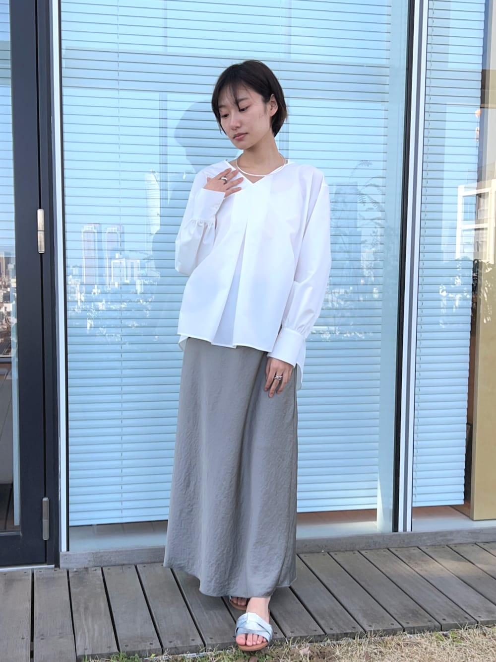 ホワイト系のシャツ/ブラウス、グリーン系のスカートを着用したレディースの春コーディネートの2枚目の写真