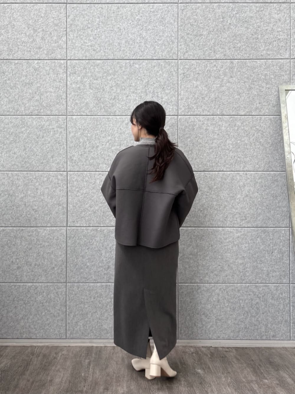 グレー系のニット/セーター、グレー系のワンピース、グレー系のブルゾンを着用したレディースの秋コーディネートの4枚目の写真