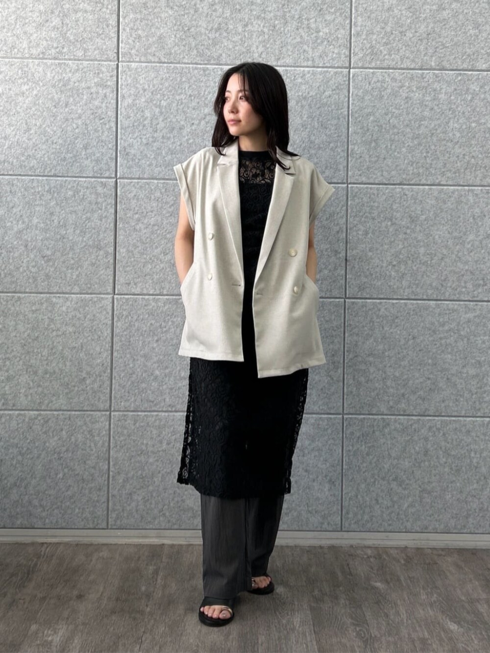 グリーン系のテーラードジャケット、ブラック系のワンピース、グレー系のその他パンツを着用したレディースの夏コーディネートの2枚目の写真