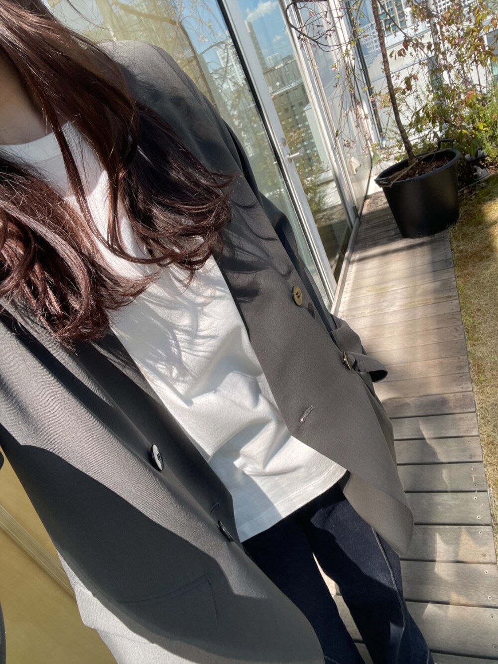 ブルー系のデニムパンツ、グレー系のノーカラージャケットを着用したレディースの春コーディネートの6枚目の写真