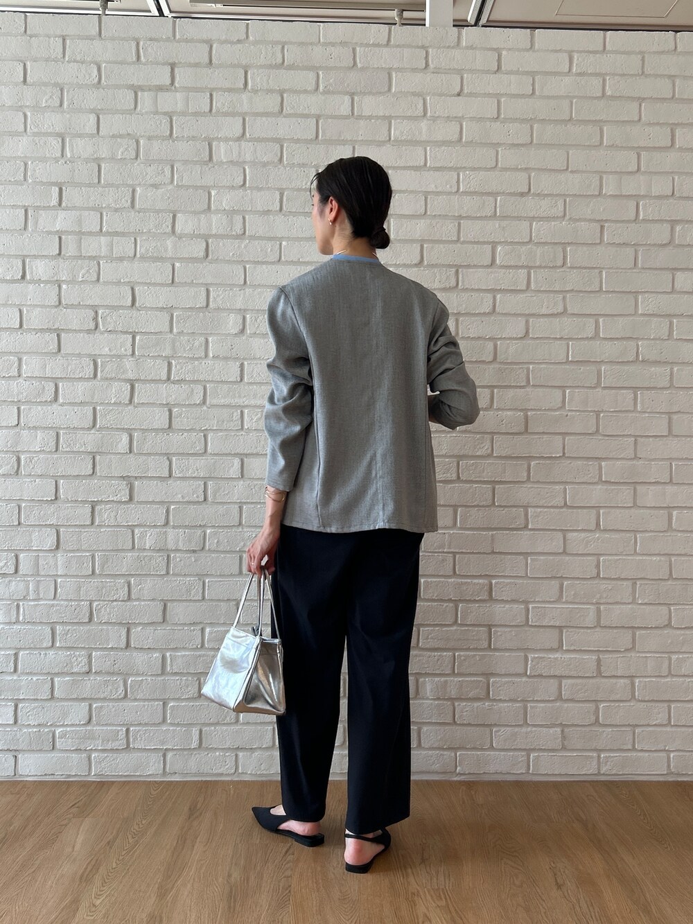 ブルー系のニット/セーター、グレー系のノーカラージャケット、ブラック系のその他パンツを着用したレディースの春コーディネートの4枚目の写真