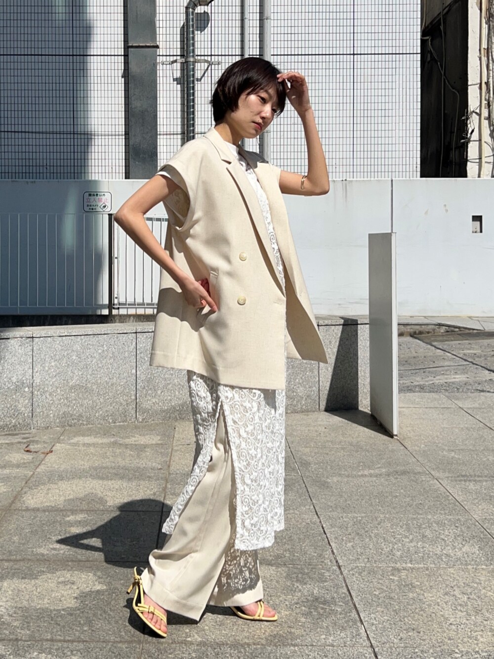 ホワイト系のタンクトップ、ホワイト系のテーラードジャケット、ホワイト系のワンピースを着用したレディースの春コーディネートの6枚目の写真