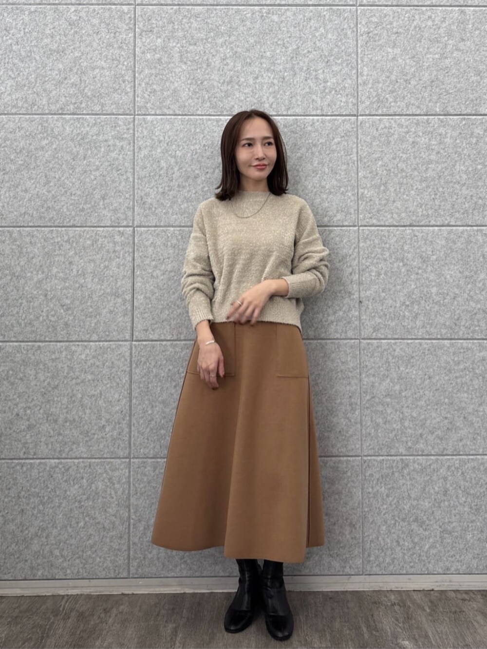 ベージュ系のニット/セーター、イエロー系のスカートを着用したレディースの秋コーディネートの2枚目の写真