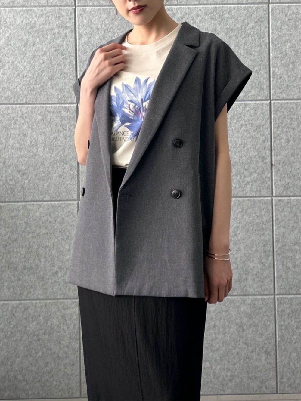 ブラック系のスカート、グレー系のテーラードジャケット、ベージュ系のTシャツ/カットソーを着用したレディースの夏コーディネートの5枚目の写真